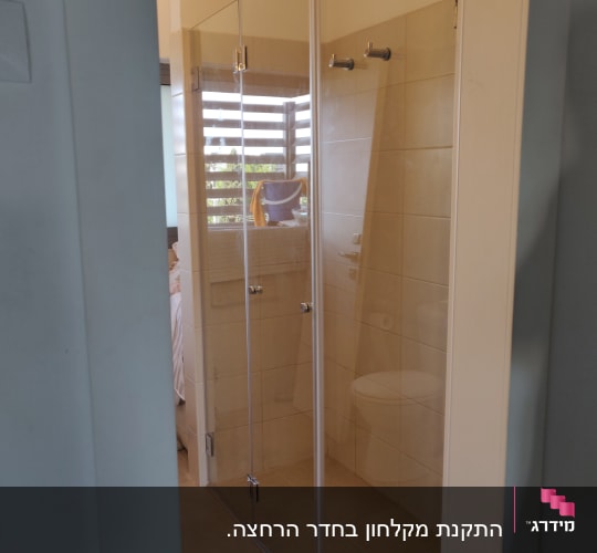 מקלחון זכוכית עם דלתות שקופות ומוט תלייה